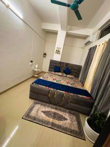グワーハーティーにあるThe Blue Orchid Homestayのベッドと天井扇風機のある寝室