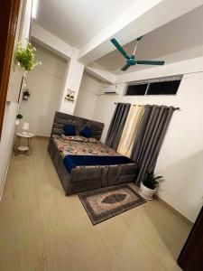 グワーハーティーにあるThe Blue Orchid Homestayのベッドと天井扇風機のある寝室