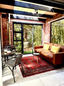 una sala de estar con un sofá y una mesa en The Secret Garden Hideaway, en Mossel Bay