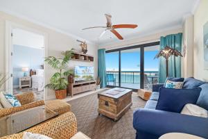a living room with blue furniture and a view of the ocean at Grand Pointe Unit 706 in Orange Beach +46 photos