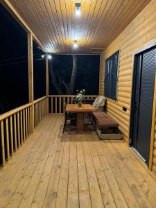une terrasse en bois avec une table et un banc dans l'établissement Good Home in Dendropark, à Stepanavan