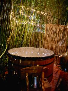 Un barril con una silla en un jardín con luces. en The Secret Garden Hideaway, en Mossel Bay