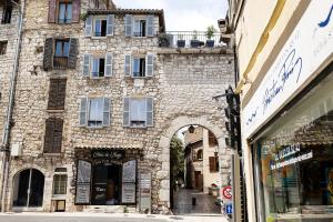 ヴァンスにあるLa Sanverine private room Boheme, historic center Venceの店の前にアーチがある古い石造りの建物