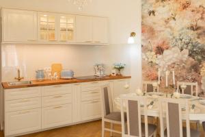 a kitchen with white cabinets and a table with chairs at Tynska apartment in Prague +25 photos