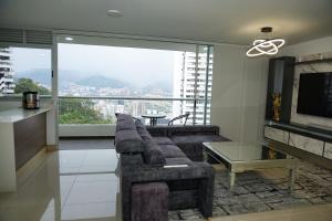 a living room with a couch and a large window at Luxurious apartment in Las Palmas in Medellín