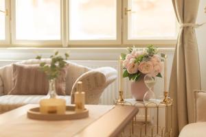 a living room with a table with a vase of flowers at Tynska apartment in Prague