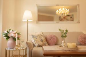 a living room with a couch and a table with flowers at Tynska apartment in Prague