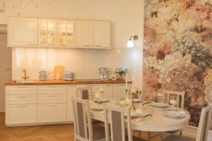 a kitchen with a table with chairs and a painting at Tynska apartment in Prague