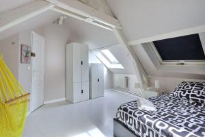 una camera da letto con un letto bianco e nero e lucernari di Le Repaire du Lion - Quadruplex - 10 voyageurs a Belfort