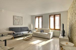 un soggiorno con un divano e una TV di Le Repaire du Lion - Quadruplex - 10 voyageurs a Belfort