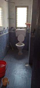 a small bathroom with a toilet and a window at Urvi Girls' Pg in Pune