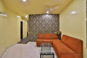 een woonkamer met een bank en een tafel bij Hotel O Kalash Residency in Ahmedabad