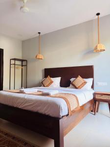 a bedroom with a large bed with white sheets at Beachwaves cottages by Tvessa in Morjim