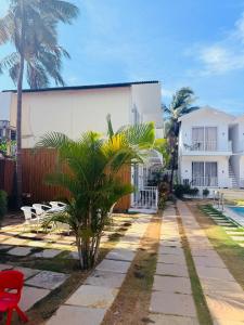 a resort with a palm tree and a building at Beachwaves cottages by Tvessa in Morjim +20 photos