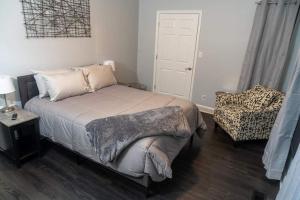 a small bedroom with a bed and a chair at Modern 3BDRM, Renovated, Spacious & Central in Evansville
