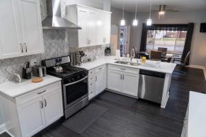 a kitchen with white cabinets and stainless steel appliances at Modern 3BDRM, Renovated, Spacious & Central in Evansville