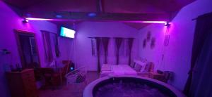 a purple room with a bed and a tub at Casuța Casa Dia in Cisnădie