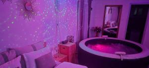 a purple bathroom with a tub and a mirror at Casuța Casa Dia in Cisnădie