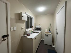 a small kitchen with a sink and a microwave at Dural paradise in Dural