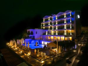 a hotel with blue lighting in front of it at night at Meis Exclusive Hotel in Kaş