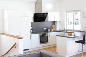 a kitchen with white cabinets and a black microwave at Walser Berghaus in Riezlern