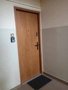 a wooden door in a room with a black door mat at Dwupokojowe mieszkanie 36 m 2 z balkonem in Siedlce