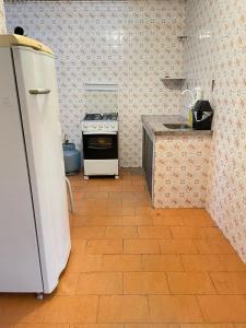a kitchen with a stove and a refrigerator in it at Casa em área nobre de Juiz de Fora in Juiz de Fora