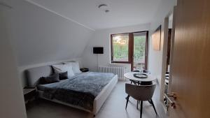 a bedroom with a bed and a table and a window at Pension mit Meer in Cuxhaven