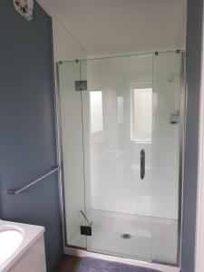 a shower with a glass door in a bathroom at Garden Studio in Rotorua