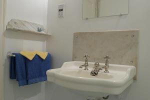 a bathroom with a white sink and a mirror at Au Pontmevault in Plouër-sur-Rance