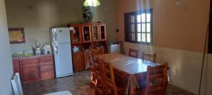 een keuken met een tafel en een witte koelkast bij Cabaña Cerca del rio Cabalango in Cavalango +11 foto's