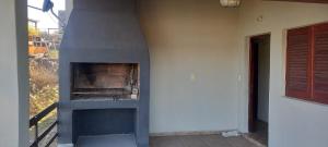 een open haard aan de zijkant van een huis bij Cabaña Cerca del rio Cabalango in Cavalango