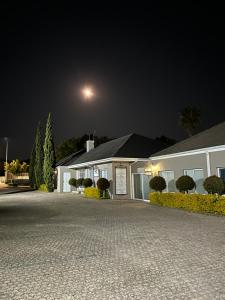 a house at night with a moon in the sky at Somerset West Garden Apartments 4 in Somerset West
