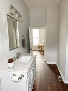 a white bathroom with a sink and a mirror at Modern 4 BDRM Renovated Spacious near U of E and Downtown in Evansville