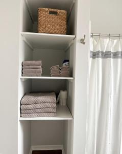 a bathroom closet with towels and a shower curtain at Modern 4 BDRM Renovated Spacious near U of E and Downtown in Evansville
