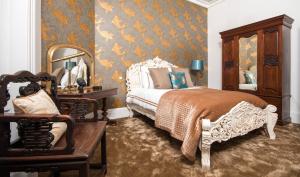 a bedroom with a bed and a chair and a mirror at Firlands in Forres