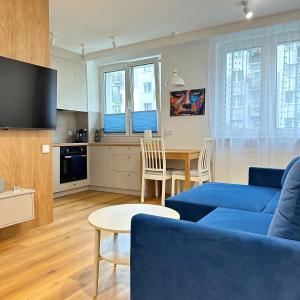 a living room with a blue couch and a table at Apartament Blue in Bartoszyce