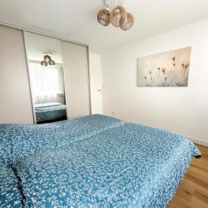 a bedroom with a blue bed and a mirror at Apartament Blue in Bartoszyce