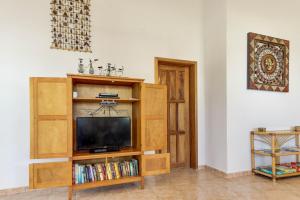 a living room with a tv and a book shelf at View the Blue -Upper Level -Gold Standard Certified in Cayo Romero