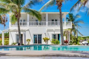 a villa with a swimming pool and palm trees at View the Blue -Upper Level -Gold Standard Certified in Cayo Romero