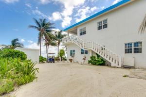 a white building with a staircase next to a beach at View the Blue -Upper Level -Gold Standard Certified in Cayo Romero