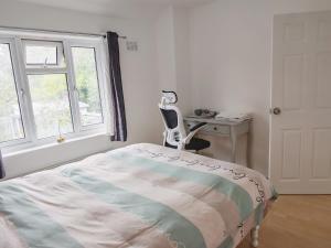 a bedroom with a bed and a desk and a chair at Home too in London