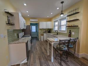 Una cocina con gabinetes blancos y una mesa y sillas. en Bayside Bungalow-Updated Home Near the Bay & Beach, en Atlantic City
