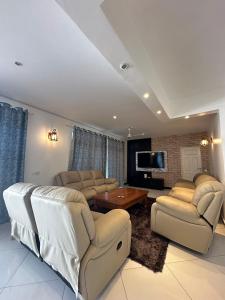 een woonkamer met banken en een flatscreen-tv bij Nyumba Alfajiry in Malindi