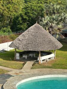 een grote strohut naast een zwembad bij Nyumba Alfajiry in Malindi +30 foto's