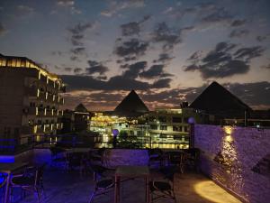 a view of the pyramids from a rooftop restaurant at night at Red Pyramids Hotel in Cairo