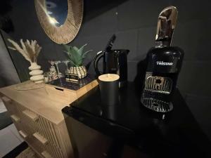 a black counter with a bottle of wine on it at Au bât Tournai chambre Bohème in Tournai