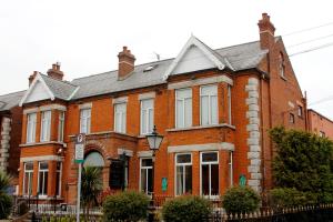 uma casa de tijolos vermelhos com um telhado preto em Maples House Hotel em Dublin