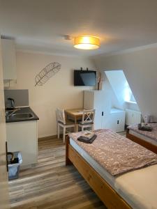 a room with a bed and a kitchen with a table at Altstadt Pension Herborn in Herborn