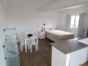 a room with a bed and a table and chairs at KIT Rayar in Alto Paraíso de Goiás